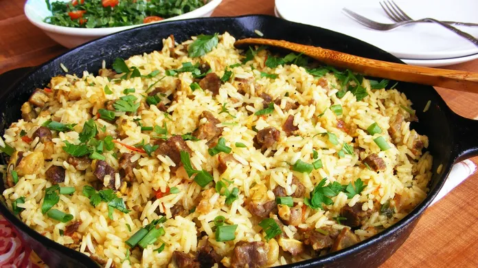 Prato de arroz Maria Isabel com farofa crocante, típico da culinária piauiense, servido em travessa branca.
