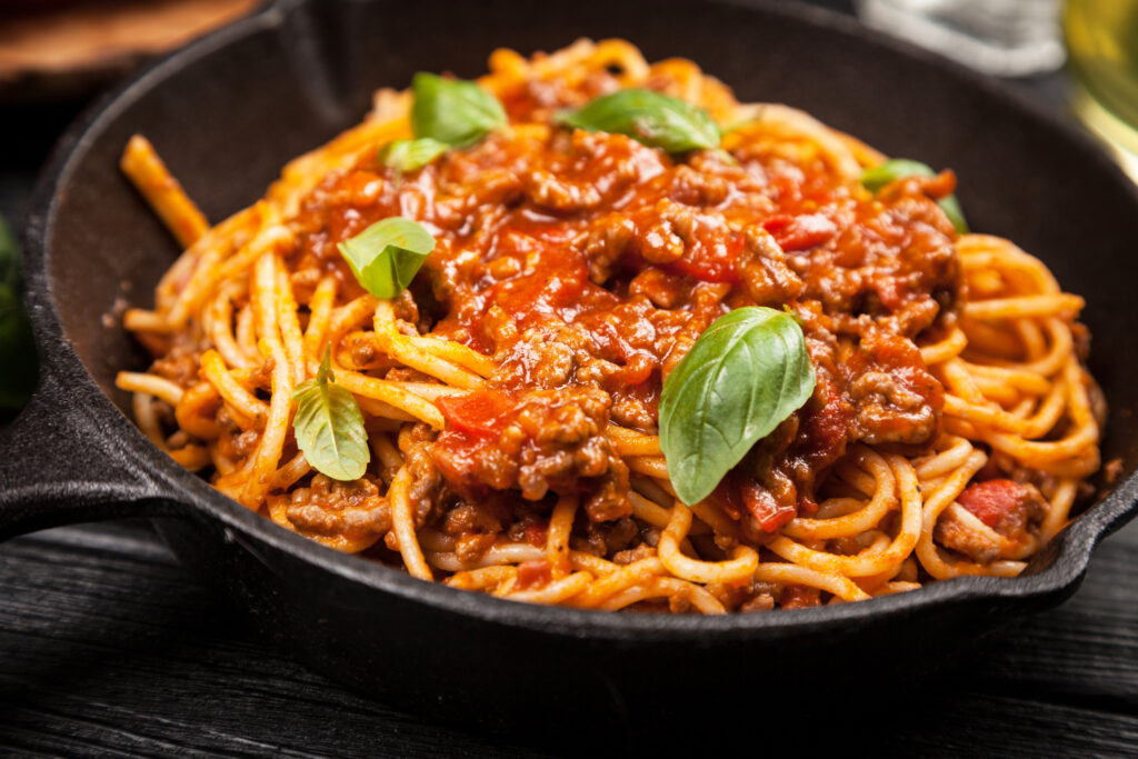 Macarronada com Molho de Carne: Prato com macarronada coberta por molho de carne encorpado, ideal para a receita completa para reunir todo mundo.